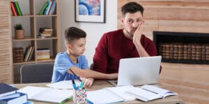 Father and son looking for online school